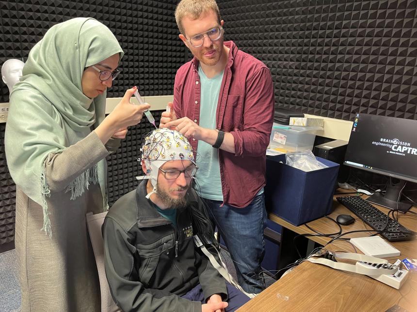 Dr. Chacòn and graduate student Hareem Khokhar apply saline solution to the EEG machine cap.