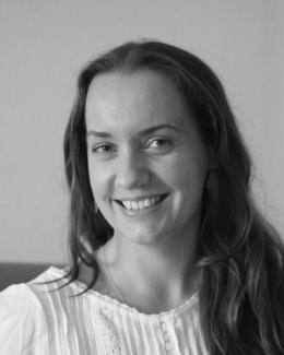 Lena Borise is smiling wearing a light colored blouse.