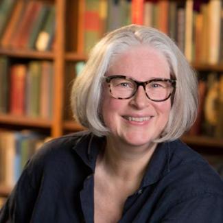 Photograph of Kim Waters in front of bookcase