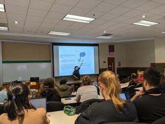 Dr. Yoshida presenting in front of classroom while attendees watch