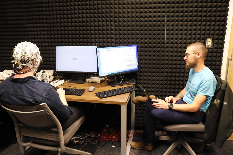 Ph.D. student Donnie Dunagan monitors as Dr. Chacón's brain activity is measured.