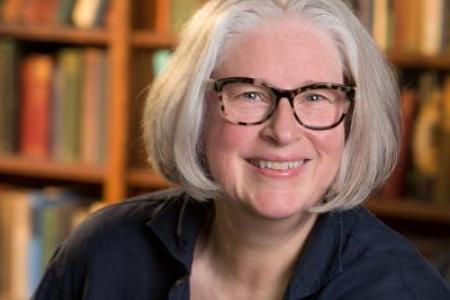 Photograph of Kim Waters in front of bookcase