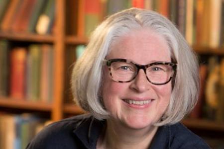 Photograph of Kim Waters in front of bookcase